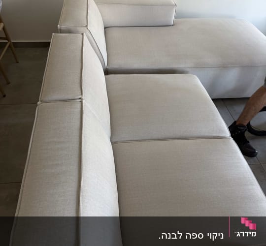 ספת בד בהירה ומעוצבת לאחר ניקוי יסודי בסלון הבית